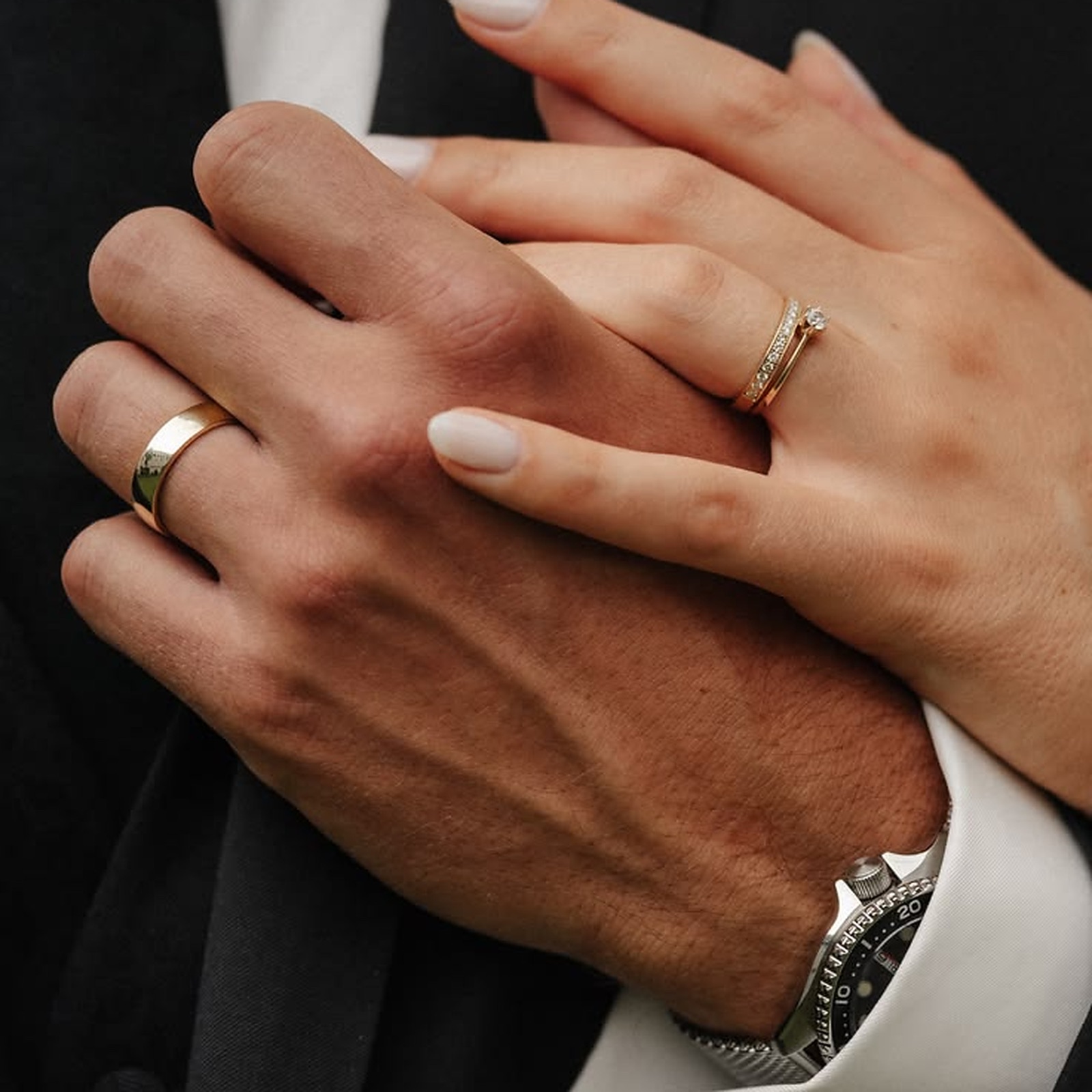 Mãos de casal com alianças de ouro